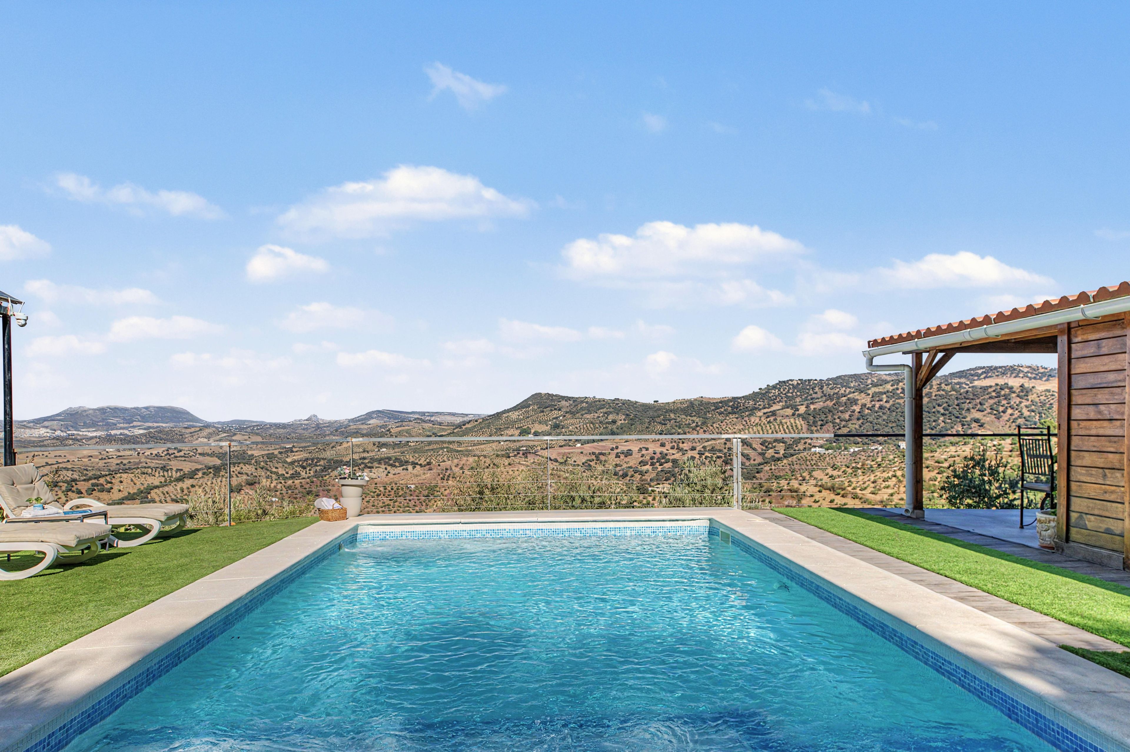 Ein Pool mit Blick auf eine hügelige Landschaft.
