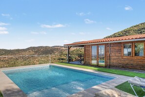 A pool area with a wooden deck, a covered seating area, and a view of the hills. - Holiday Home 'Miralvalle' with Mountain View, Wi-Fi and Air Conditioning (El Gastor)