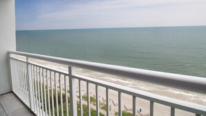 A balcony with a view of the ocean and beach.