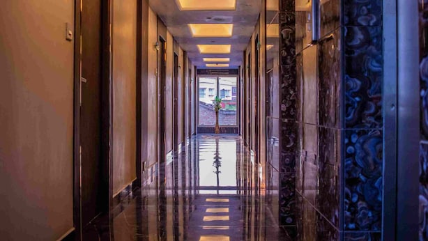 A long, polished hallway with reflective floors and a central decorative element. - continental lodge  (Malda)