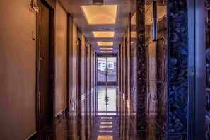 A long, polished hallway with reflective floors and a central decorative element. - continental lodge  (Malda)