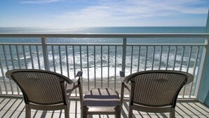 A balcony with two chairs facing the ocean, a railing, and a view of the sea. - Unwind 1BR Oceanfront King Deluxe Condo 12th Floor (Myrtle Beach)