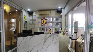 A reception area with a marble counter, glass doors, and a sign indicating a 2-meter social distancing guideline. - Sunny Day Residences Cainta (Cainta)