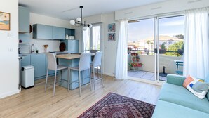 A modern apartment with a kitchen, dining area, and a balcony with a view. - Apartment 'Appart Anglet' with Private Terrace (Anglet)