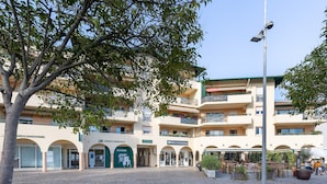 A building with multiple floors, outdoor seating, and a cobblestone ground. - Apartment 'Appart Anglet' with Private Terrace (Anglet)