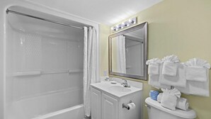 A bathroom with a bathtub, a sink, a toilet, a mirror, and towels. - Oceanview Room  2 Queen Beds: 12th Floor (Myrtle Beach)