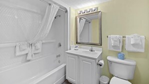 A bathroom with a shower, a sink, a toilet, and a mirror. - Escape to Paradise Resort OV King Room 9th Floor (Myrtle Beach)