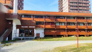 Un edificio a più piani con facciata in legno e un cartello che riporta la scritta "PELVOX VERCORS".