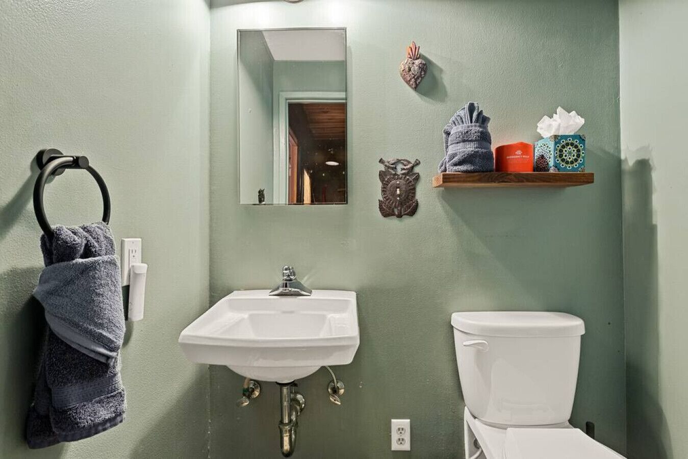 Une salle de bain avec un lavabo blanc, des toilettes et un porte-serviettes.