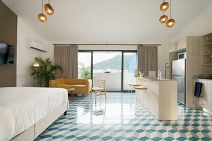 Una camera d'hotel con un letto, un divano, un'area pranzo e una cucina.