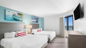 A hotel room with two beds, a TV, artwork on the wall, and a view of the sea. - 14th Floor Oceanfront Corner Balcony 2BR Condo (Myrtle Beach)