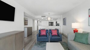 A modern living room with a sofa set, a coffee table, and a TV mounted on the wall. - Shoreline Oceanfront 11th Floor 3BR Condo (Myrtle Beach)