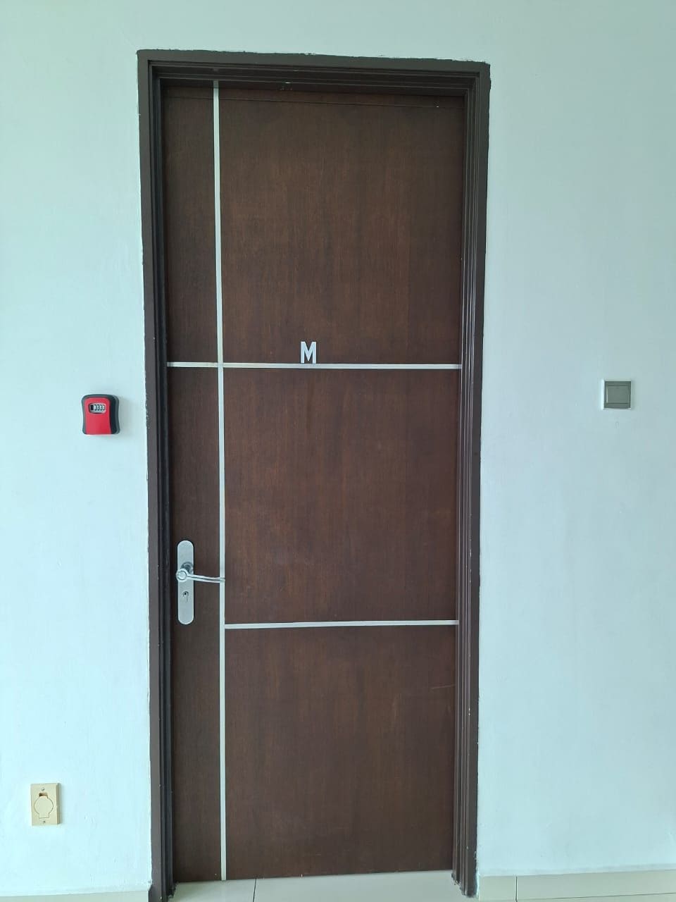 A closed wooden door with a metal handle and a keyhole.