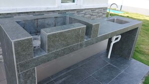 A modern outdoor kitchen with a built-in sink and a stone countertop. - Alpine PD Taman Kiara 2 Homestay (Port Dickson)