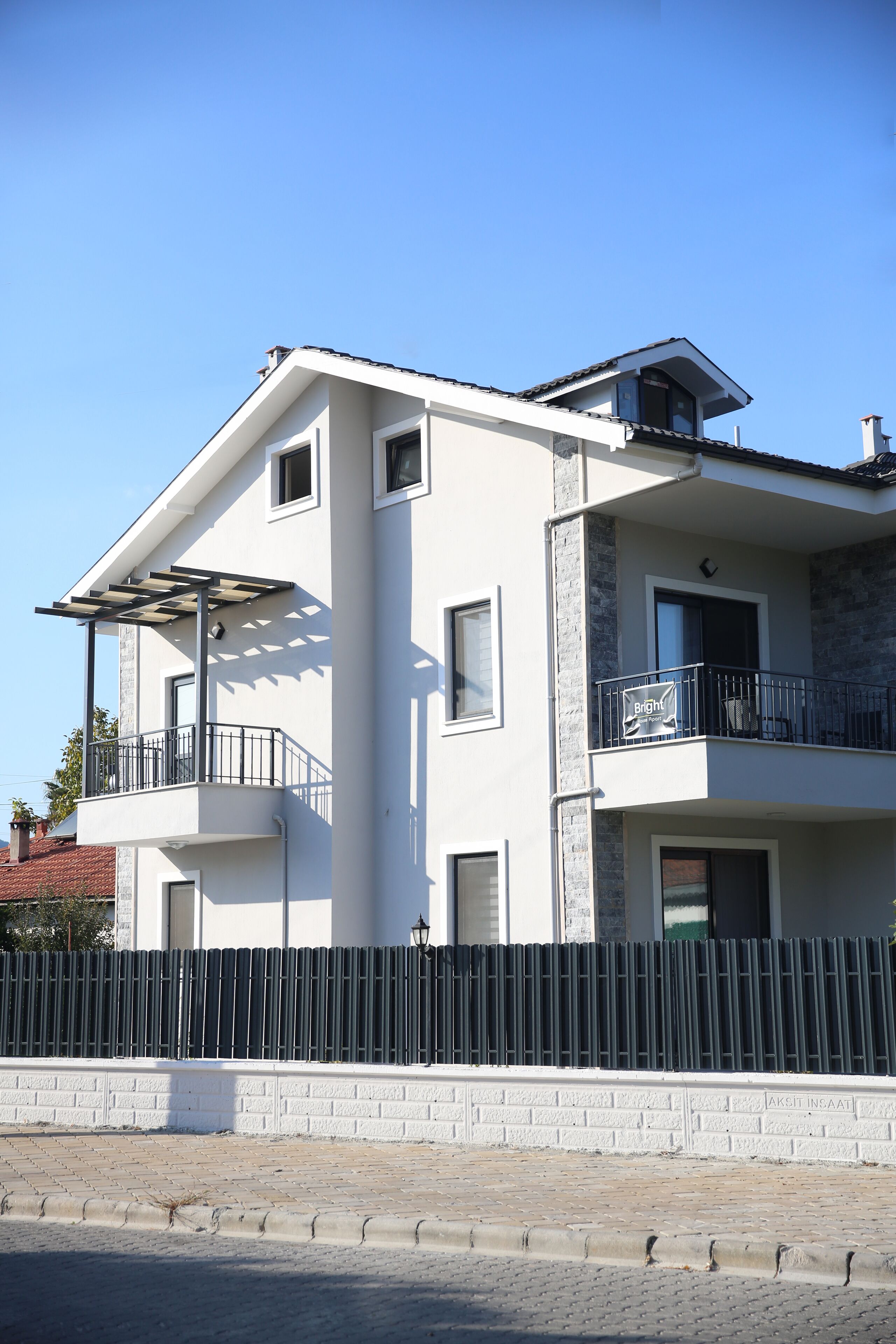 A two-story building with a balcony, a small window, and a door.