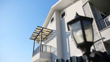 Un bâtiment moderne doté d’un balcon, d’une pergola et d’un lampadaire.