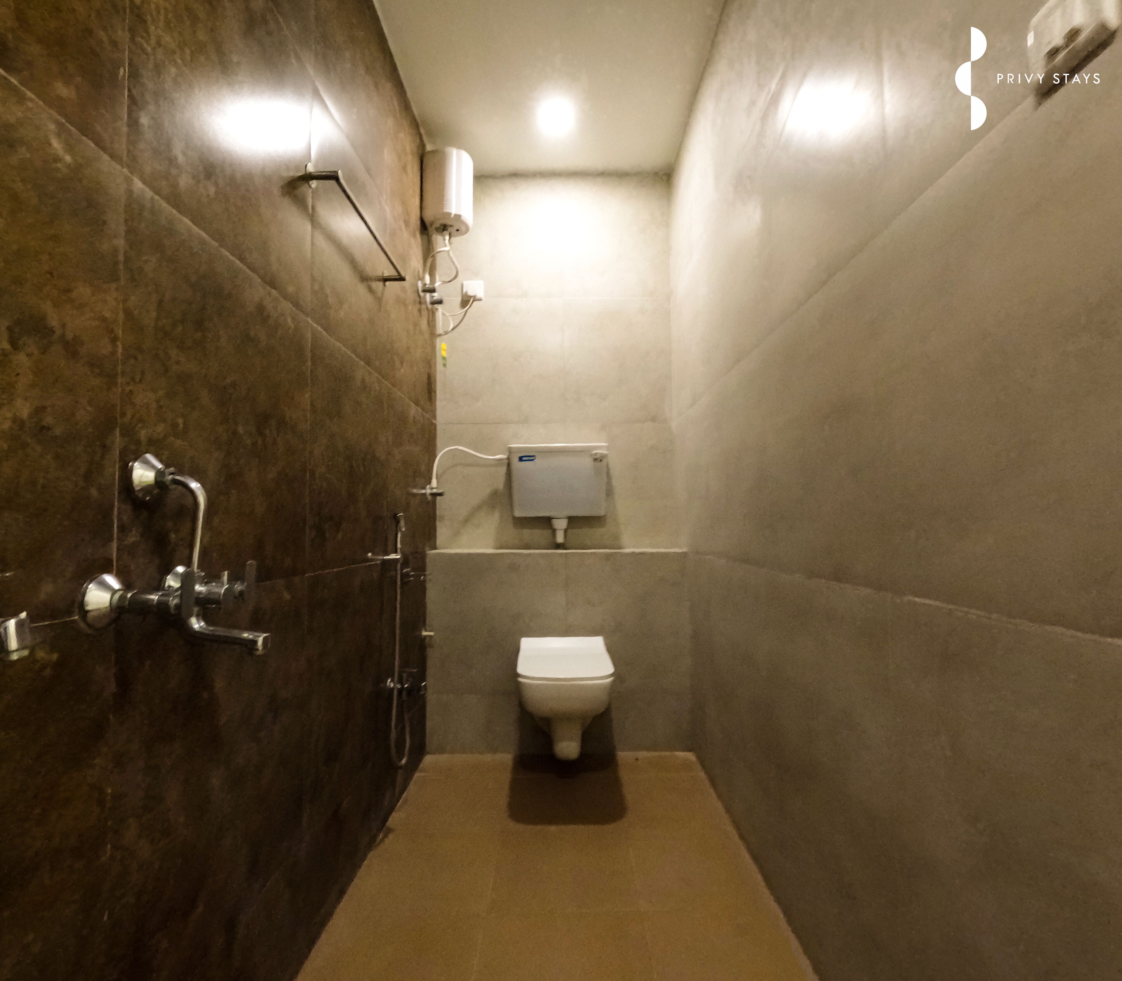 A bathroom with a toilet, a shower, and a towel rack.