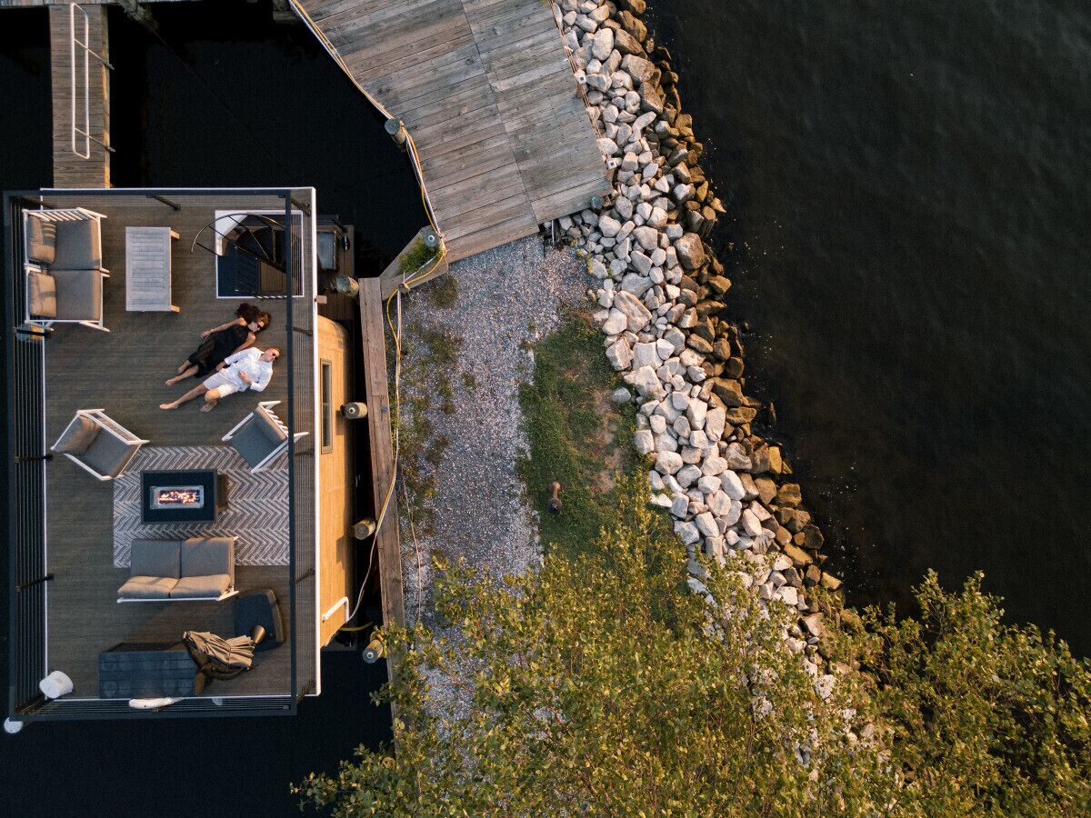 A wooden deck with outdoor seating and a view of the water.
