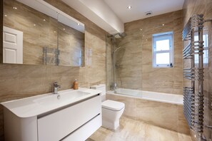 A modern bathroom with a large white sink, a toilet, and a glass-enclosed shower. - Enchanting Light, by Veeve (London)