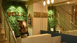 A hotel reception area with a green wall, a marble counter, and a staircase. - Bella Otel Mudanya  (Mudanya)