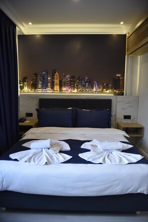 A hotel room with a bed, pillows, a nightstand, and a cityscape view. - Bella Otel Mudanya  (Mudanya)