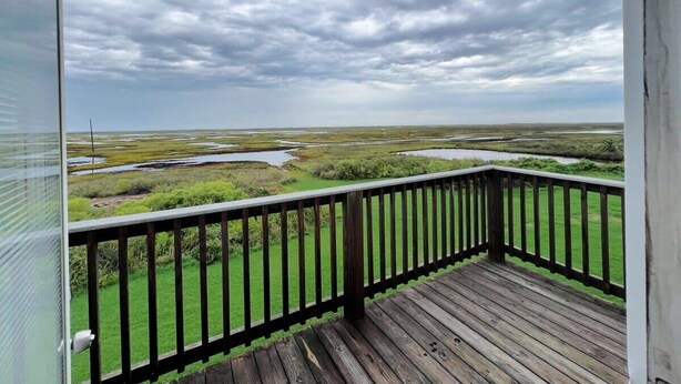 A wooden deck with a view of a wetland area. - Ocean Pearl - Ultimate Beach & Boat Watch Escape! (Surfside Beach)