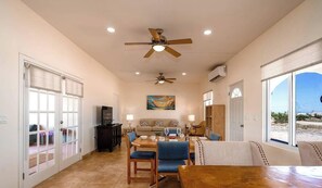 A spacious living area with a dining table, blue chairs, a sofa, and a ceiling fan. - Casa Desert Rose  -| 2BR, 2BA oasis for up to 6 guests. (San Felï¿½pe)