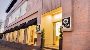 Un hotel modern amb una entrada destacada, un rètol que diu 'Revive Boutique Hotel' i una façana ben il·luminada.
