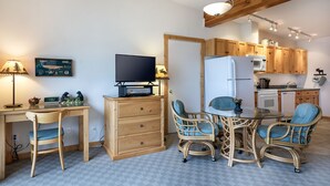 A compact kitchen with wooden cabinets, a refrigerator, and a microwave. - Lakefront Studio with views! (Bigfork)