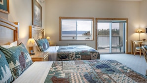 A hotel room with two beds, a desk, a chair, and a view of a lake. - Lakefront Studio with views! (Bigfork)