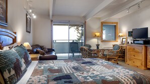 Une chambre à coucher avec un grand lit, un bureau, une chaise et un téléviseur.
