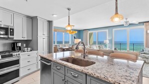 A modern kitchen with granite countertops, stainless steel appliances, and a large island with a sink. - Blu 501 ~ Luxury End-Unit w/3 Master Suites & Amazing Oceanfront Views ~ Sleeps 8 (Fort Walton Beach)
