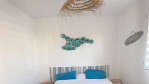 A bedroom with a bed, nightstands, a woven ceiling light, and decorative wall art. - House in Piriac Sur Mer ideal for spending time with family or friends. (Piriac-sur-Mer)