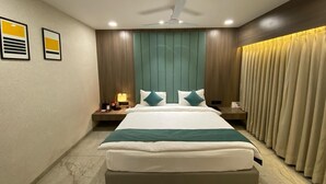 A modern hotel room with a large bed, a ceiling fan, and a nightstand with a lamp.