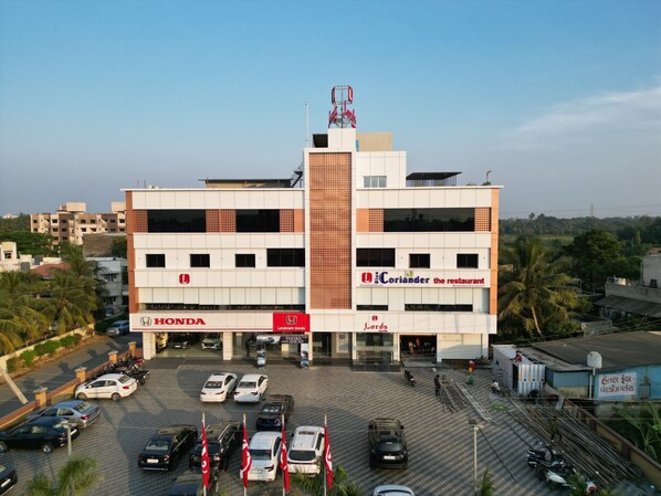 A multi-story building with a Honda dealership on the ground floor and a restaurant named "The Coriander" on the second floor.