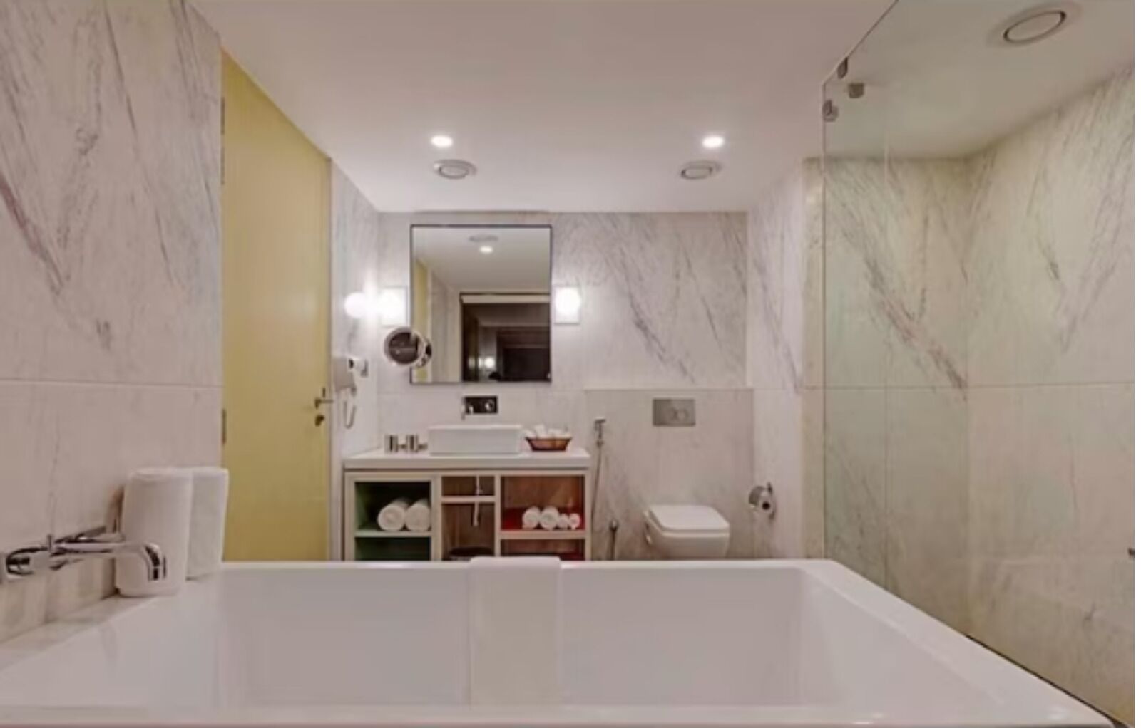 Een moderne badkamer met een ruime badkuip, een wastafel met spiegel en een douchehoek.