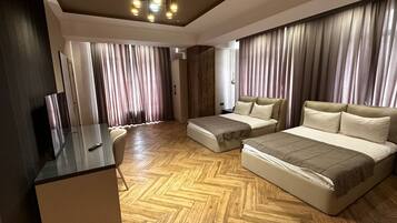 Habitación cuádruple familiar | Ropa de cama de alta calidad, minibar, caja fuerte y escritorio