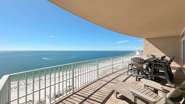 A balcony with a view of the ocean and beach, featuring outdoor furniture and a railing. - Beachfront 4BR Corner Unit!  Lazy River and Water Slide!! (Orange Beach)