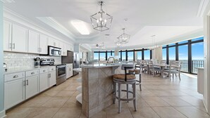 A spacious kitchen with modern appliances, a central island, and a dining area with a view.