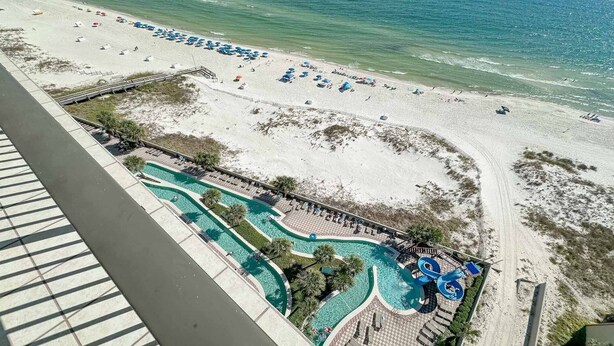 A resort with a large pool area, a beach, and a boardwalk.