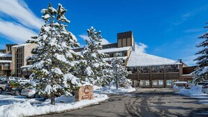 Un edificio cubierto de nieve con un estacionamiento y varios coches.