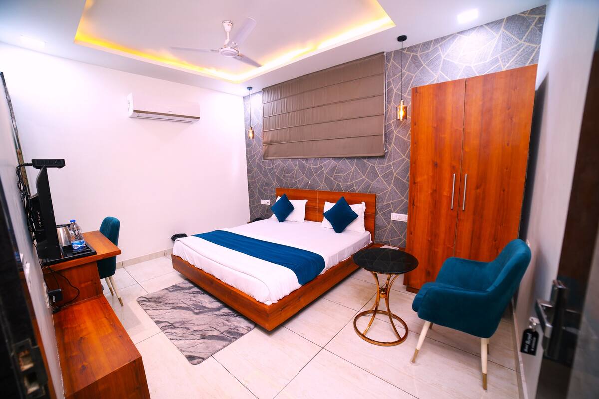 Un dormitorio moderno con cama, escritorio, silla, armario y ventilador de techo.