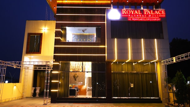 Een modern hotel met een opvallend bord waarop staat: 'Royal Palace Banquet Hall'.