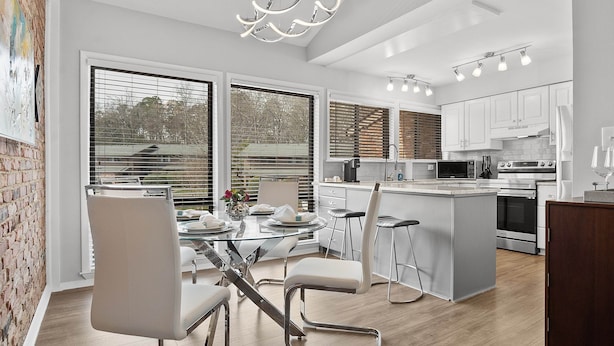A modern kitchen with white cabinets, stainless steel appliances, and a central island. - Only two miles to UNC campus (Chapel Hill)