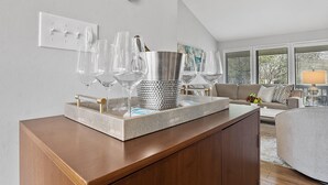 A modern living room with a wooden coffee table, a metal tray with wine glasses, and a sofa in the background. - Only two miles to UNC campus (Chapel Hill)