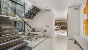 Ein modernes Interieur mit Treppe, Sofa, Couchtisch und Essbereich.
