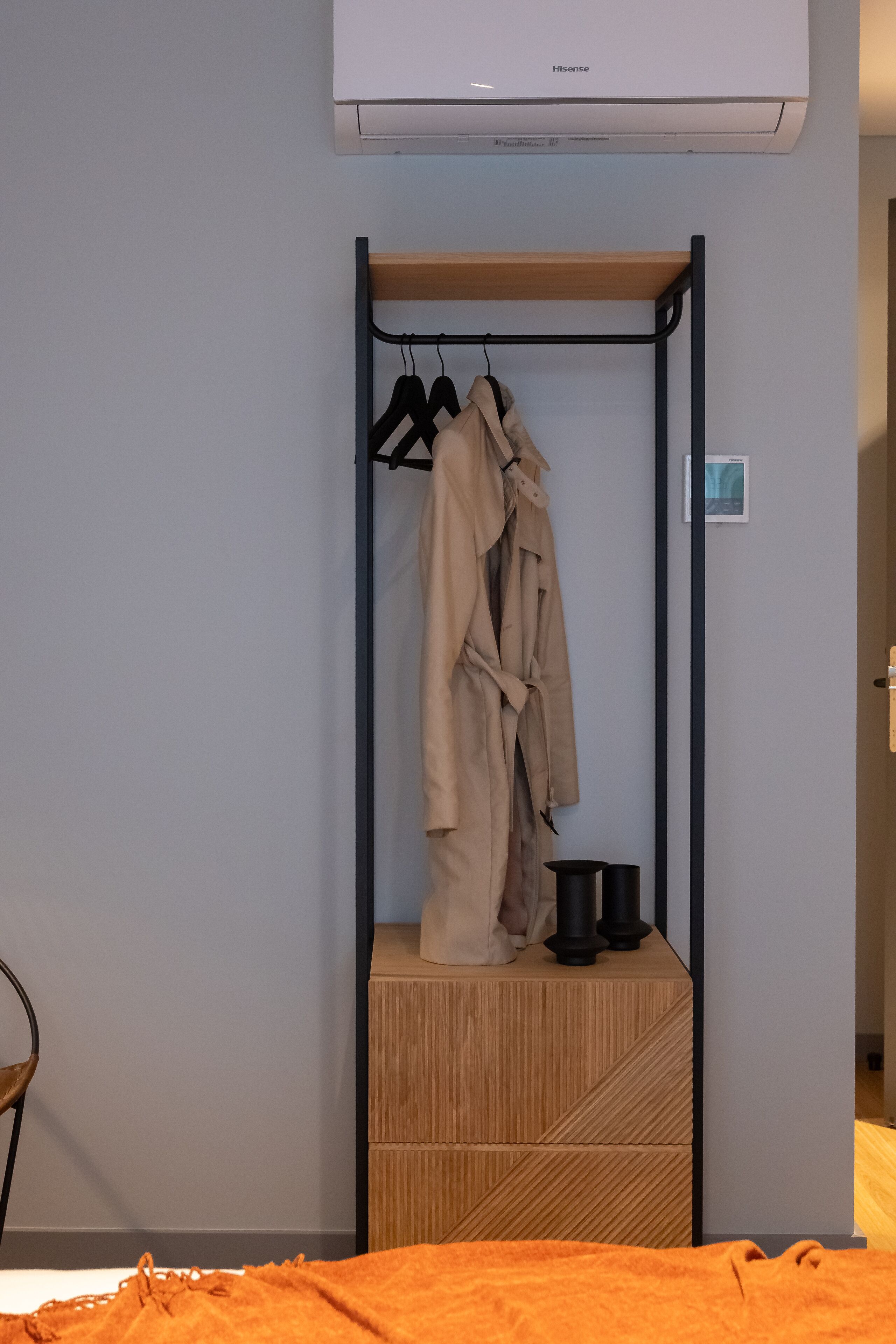 A room with a wardrobe, a bed, and a wall-mounted air conditioner.
