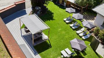 A rooftop patio with outdoor seating, a covered area, and a view of the surrounding buildings.