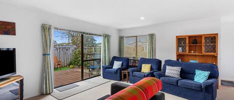 A modern living room with a sofa set, a television, and a wooden cabinet.