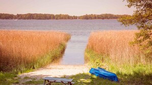 A lakeside picnic area with a bench and a covered picnic table. - Gemütlicher Bungalow in Storkow am See (Storkow)